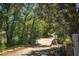 Scenic driveway leading to the property, surrounded by mature trees and lush greenery at 18480 State Hwy 160, Las Vegas, NV 89161
