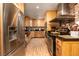 A well-equipped kitchen with stainless steel appliances, wood cabinets, and brick accent wall at 18480 State Hwy 160, Las Vegas, NV 89161