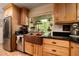 Charming kitchen with wooden cabinets, black countertops, and a copper farmhouse sink beneath a window at 18480 State Hwy 160, Las Vegas, NV 89161