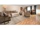 Bright living room features a sectional sofa, accent chairs, and wood floors with area rug at 18480 State Hwy 160, Las Vegas, NV 89161