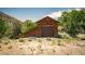 Rustic outbuilding with a garage door and simple architecture, blending with the natural desert landscape at 18480 State Hwy 160, Las Vegas, NV 89161
