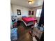 Bedroom featuring posters, a bed with a red blanket, and wood plank flooring at 1870 Upland Ave, Pahrump, NV 89048