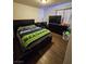 Bedroom featuring dark furniture, a fan, a TV, and a sports-themed blanket on a bed with wood plank flooring at 1870 Upland Ave, Pahrump, NV 89048