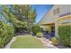 Well-maintained backyard boasting a green lawn, mature trees, and a tiled covered patio at 1941 Williamsport St, Henderson, NV 89052