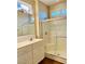 Well-lit bathroom featuring a glass-enclosed shower and a vanity with sink and white cabinets at 1941 Williamsport St, Henderson, NV 89052