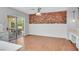 Bright dining area with hardwood floors, exposed brick wall, and sliding glass doors at 1941 Williamsport St, Henderson, NV 89052