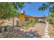 Serene backyard featuring a stone walkway, privacy landscaping, and covered patio, ideal for relaxing outdoors at 1950 Abarth St, Las Vegas, NV 89142