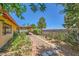 Backyard with charming walkway, mature landscaping, and a covered patio providing a serene outdoor space at 1950 Abarth St, Las Vegas, NV 89142