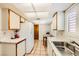 Practical kitchen layout with white cabinets, solid surface countertops, tiled floors, and bright natural light from a window at 1950 Abarth St, Las Vegas, NV 89142