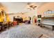 A spacious living room featuring ceiling fans, a piano, and neutral carpet at 1950 Abarth St, Las Vegas, NV 89142