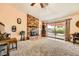Spacious living room with a cozy brick fireplace, neutral carpet, and sliding glass doors to a covered outdoor area at 1950 Abarth St, Las Vegas, NV 89142