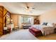A cozy main bedroom with a bright window, wood paneling, and a ceiling fan at 1950 Abarth St, Las Vegas, NV 89142