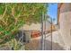 Side yard featuring mature tree providing shade, chain link fence and rock landscaping at 1950 Abarth St, Las Vegas, NV 89142