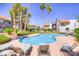 Community pool and lounge chairs surrounded by mature palm trees and manicured landscaping at 2212 Sunfish Dr # C, Henderson, NV 89014