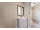 Bathroom vanity with framed mirror, complemented by a tiled shower with pebble floor at 2301 Maverick St, Las Vegas, NV 89108