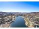 This aerial view showcases a community with a lake, beautiful homes, and a golf course at 30 Hilltop Crest St, Henderson, NV 89011