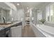 Modern bathroom boasts dual vanity, granite countertop, soaking tub, and glass shower at 30 Hilltop Crest St, Henderson, NV 89011