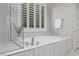 Elegant bathroom showcasing a soaking tub, walk-in shower, and bright window with plantation shutters at 30 Hilltop Crest St, Henderson, NV 89011