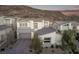 Inviting two-story home with a gray and white color scheme, mountain views, and a well-manicured front yard at 30 Hilltop Crest St, Henderson, NV 89011