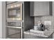 Built-in stainless steel microwave and oven with gray cabinets and designer backsplash at 30 Hilltop Crest St, Henderson, NV 89011