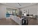 Open living room with tile flooring, white sectional sofa, and sliding glass doors to the pool area at 30 Hilltop Crest St, Henderson, NV 89011