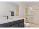 Bathroom featuring a glass-enclosed tub shower and a sleek black vanity with brass hardware at 3047 Van Buskirk Cir, Las Vegas, NV 89121