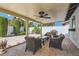 An inviting covered patio with stylish wicker furniture, ceiling fan and a gas grill in the manicured backyard at 3047 Van Buskirk Cir, Las Vegas, NV 89121