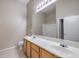 Bright bathroom featuring double sinks, wood cabinets, and a large mirror at 3351 Indian Shadow St # 204, Las Vegas, NV 89129