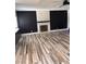 Open living room featuring a decorative fireplace, ample natural light, and stylish wood flooring at 3900 San Angelo Ave, Las Vegas, NV 89102