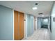 Hallway showing closet doors, tile flooring, and exit signs for safety at 3930 University Center Dr # 706, Las Vegas, NV 89119