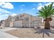 An inviting two-story home is complemented by desert landscaping and a mature palm tree in the front yard at 4604 Barnes Ct, Las Vegas, NV 89147
