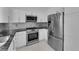 Modern kitchen featuring stainless steel appliances, granite countertops, and tile floors at 4604 Barnes Ct, Las Vegas, NV 89147