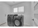 Laundry room features black front loading washer and dryer at 4604 Barnes Ct, Las Vegas, NV 89147