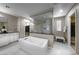 Bright bathroom with a soaking tub, glass-enclosed shower, white cabinets and a walk-in closet at 4702 Amazing View St, Las Vegas, NV 89129