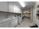 Well-organized laundry room with white cabinets, modern appliances, and an ironing station at 4702 Amazing View St, Las Vegas, NV 89129