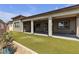 A view of the back of the house with a covered patio and artificial turf at 4829 E Beacon Ridge Dr, Pahrump, NV 89061