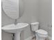 A modern half-bathroom featuring a stylish pedestal sink and a efficient toilet at 4829 E Beacon Ridge Dr, Pahrump, NV 89061