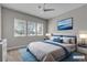 A cozy bedroom with bright windows, a ceiling fan, a plush bed, and stylish decor at 4829 E Beacon Ridge Dr, Pahrump, NV 89061