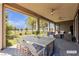 Covered patio with dining and seating areas, ceiling fans, and artificial turf backyard at 4829 E Beacon Ridge Dr, Pahrump, NV 89061