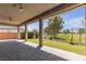 Covered patio features brick pavers and artificial turf backyard with a golf course view at 4829 E Beacon Ridge Dr, Pahrump, NV 89061