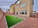 Enclosed backyard featuring artificial grass and brick-lined borders at 5699 Woodchester Ave, Las Vegas, NV 89139