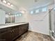 Primary bathroom with double vanity, large mirror, tile flooring, and walk-in shower at 5699 Woodchester Ave, Las Vegas, NV 89139
