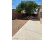 Low-maintenance backyard with gravel, mature tree, and a concrete patio, surrounded by a brick wall at 6113 Desert Haven Rd, Las Vegas, NV 89130