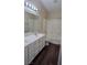 Bright bathroom featuring a dual sink vanity, dark wood flooring, and a shower over tub at 6113 Desert Haven Rd, Las Vegas, NV 89130