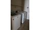 Functional laundry room equipped with a washing machine, dryer, and overhead storage shelves at 6113 Desert Haven Rd, Las Vegas, NV 89130