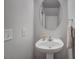 Updated half bathroom features a pedestal sink, updated hardware, and modern fixtures at 622 Quaint Acres Ave, Las Vegas, NV 89183
