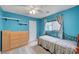 Bedroom features a bright blue color scheme with modern shelving and a metal bed frame at 622 Quaint Acres Ave, Las Vegas, NV 89183