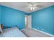 Comfortable bedroom with blue walls offering a calm, relaxing space with a cozy bed and neutral carpeting at 622 Quaint Acres Ave, Las Vegas, NV 89183