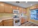 Bright kitchen with wood cabinets, white appliances, and an oven range at 622 Quaint Acres Ave, Las Vegas, NV 89183