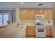 Kitchen features wood cabinets, a white range, and a sunny view at 622 Quaint Acres Ave, Las Vegas, NV 89183